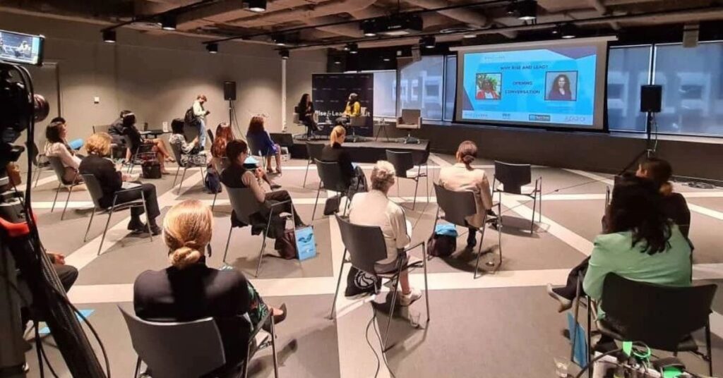 Hybrid conference setup with live audience and virtual streaming screens.