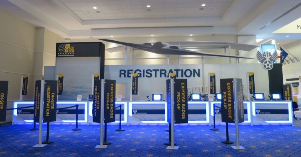 Elegant corporate event entrance with branded registration counters and directional signage, and welcoming staff.