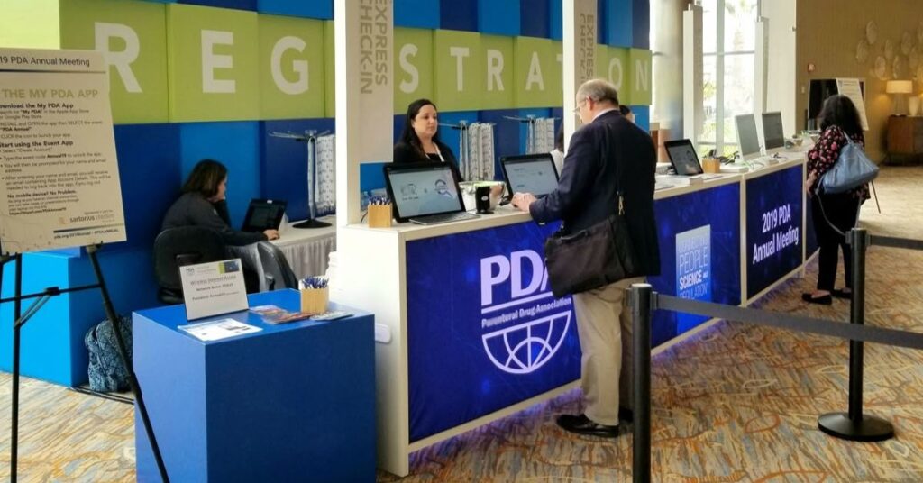 Description: Registration team warmly welcoming guests while assisting with digital check-in.